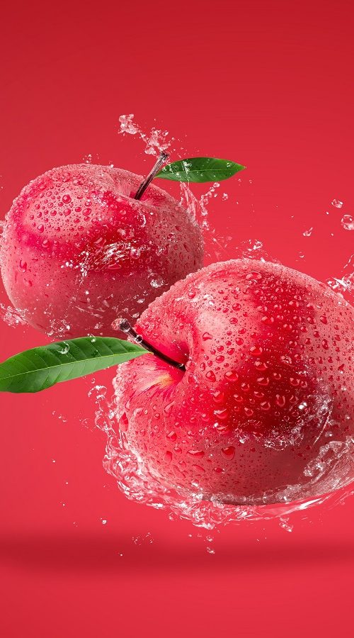 Water splashing on Fresh Red apple on red background.